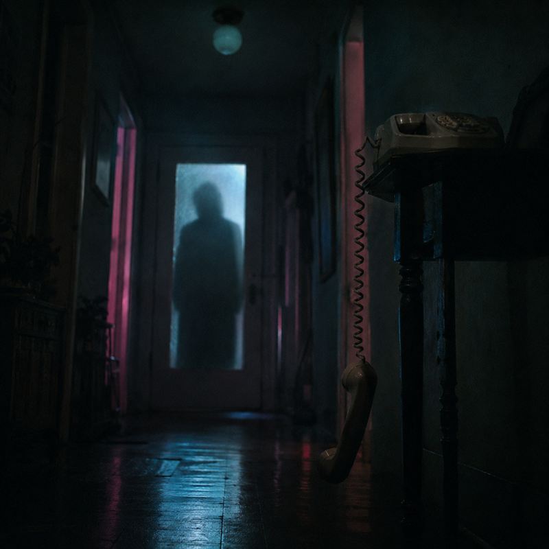 Couloir sombre d'une maison hantée éclairé de rose et de bleu, ambiance de décoration Halloween